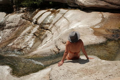 Rear view of woman standing on rock