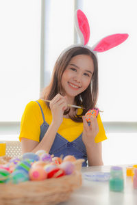 Portrait of smiling woman decorating easter egg