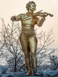 Low angle view of statue against bare tree