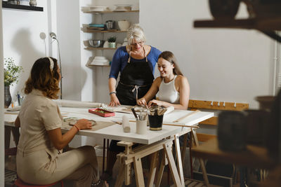 Pottery workshop in studio. people working with clay on the table. adults learning to do ceramic