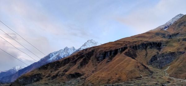 Low angle view of snowcapped mountains against sky