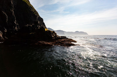 Rock formation on sea against sky