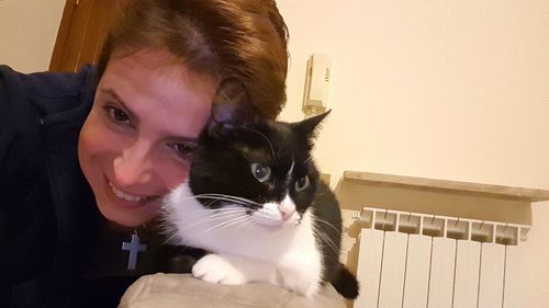 Portrait of young woman with cat at home