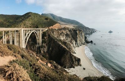 Arch bridge over sea against sky