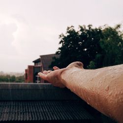 Close-up of man on roof against sky