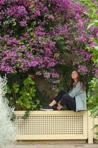 Woman sitting on purple flowering plants