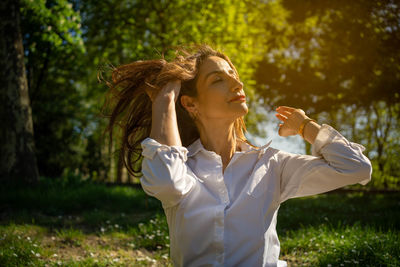Portrait of young woman blowing flowers