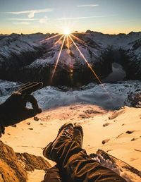 Low section of man gesturing ok sign against mountains during winter