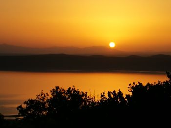Scenic view of lake against romantic sky at sunset