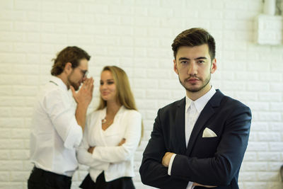 Portrait of businessman standing with colleagues in office