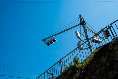 Low angle view of crane against clear blue sky