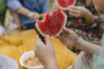 Boy holding watermelon sitting at park