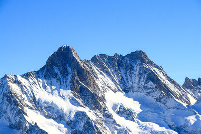 Scenic view of snowcapped mountains against clear blue sky