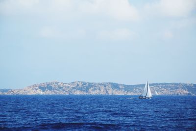 Sailboat sailing on sea against sky