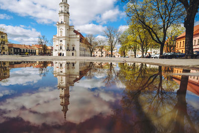 Reflection of building in puddle against sky