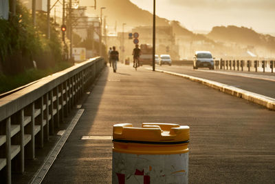 People on footpath in city at sunrise 