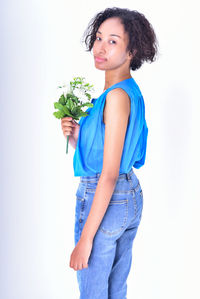 Portrait of beautiful young woman standing against white background