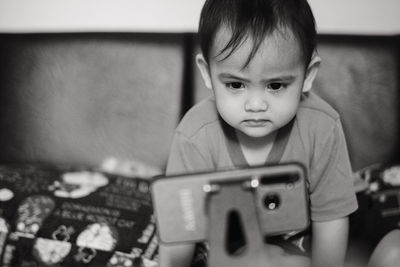 Close-up of cute girl seeing movies on mobile phone