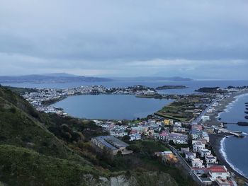 High angle view of townscape by sea against sky