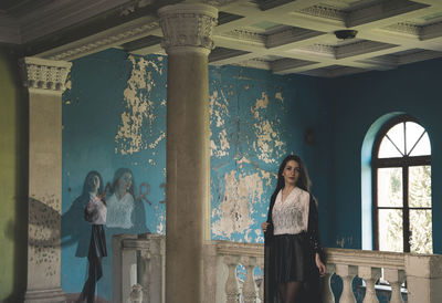 Double exposure of woman standing in abandoned house