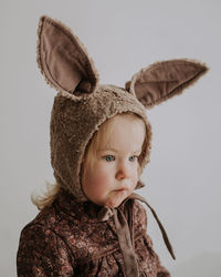 Close up portrait of toddler baby girl in funny hat with ears having fun