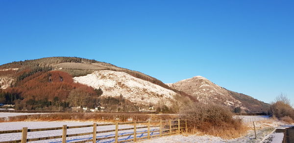 Scenic view of mountains against clear blue sky