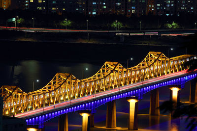 The beautiful lighting of the railway bridge sets off the night view of the city.