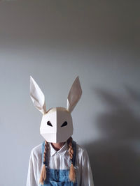 Woman wearing paper rabbit mask with space for text