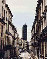 Street amidst buildings against sky in city