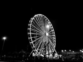 Low angle view of illuminated ferris wheel against sky at night