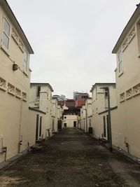 Narrow street amidst buildings against sky