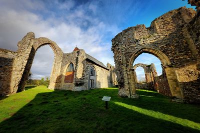 Low angle view of old ruin building against cloudy sky