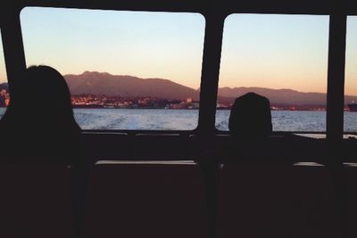 Silhouette of woman in sea at sunset