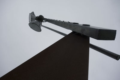 Low angle view of electric lamp against sky