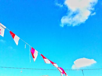 Low angle view of flags hanging against sky