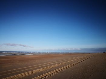 Scenic view of desert against blue sky