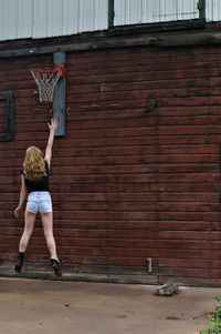 Woman jumping towards basketball hoop