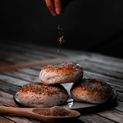 Person seasoning buns on plate