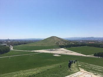 People on mountain against clear blue sky