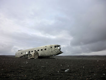 Abandoned airplane on runway against sky