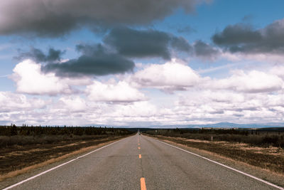 Empty road on field against sky