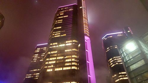 Low angle view of modern building against sky at night