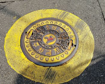 High angle view of yellow manhole on street