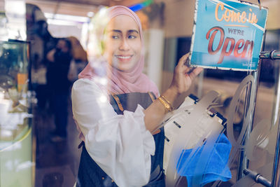 Portrait of smiling young woman standing in store