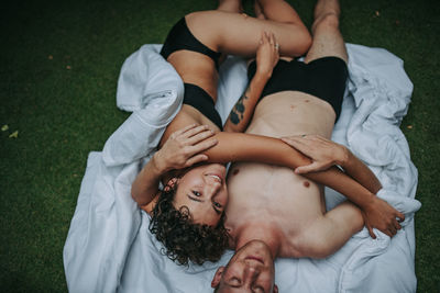 High angle view of couple relaxing on bed