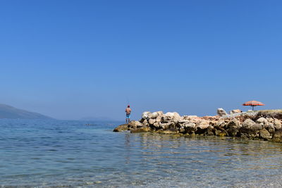 Scenic view of sea against clear blue sky