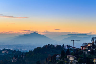 Scenic view of residential district against sky during sunset