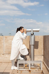 Side view of a woman standing against the sky