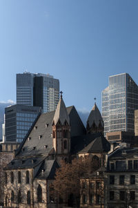 Low angle view of buildings against clear blue sky