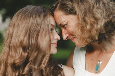 Close-up of mother and daughter looking at each other in park